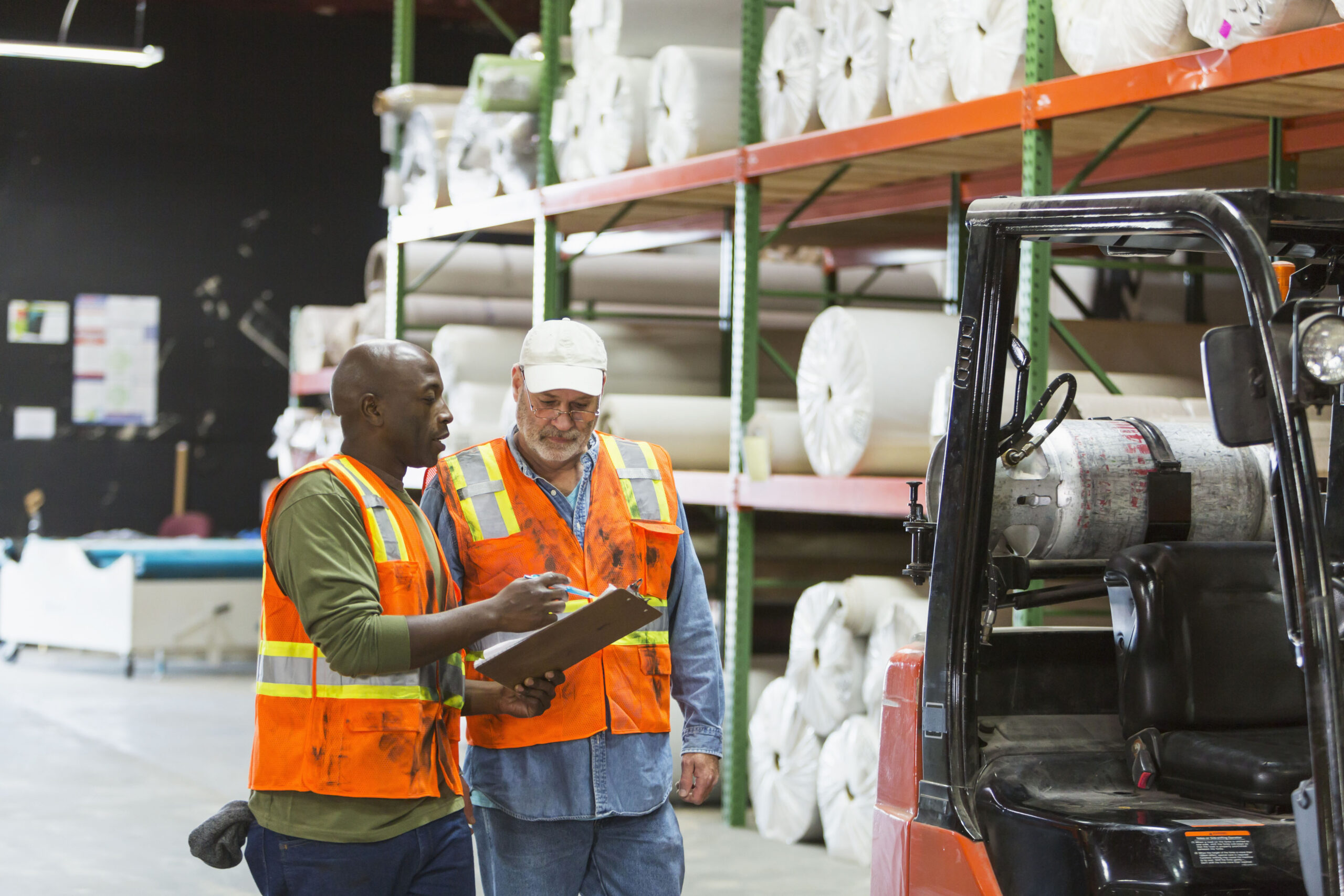 Two men working in carpet warehouse, with forklift Carpet and Flooring Industry Supply Chain Logistics